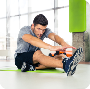 Fitness man doing stretching exercises at gym