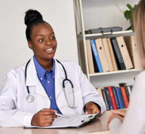 doctor explaining information on the clipboard to her patient